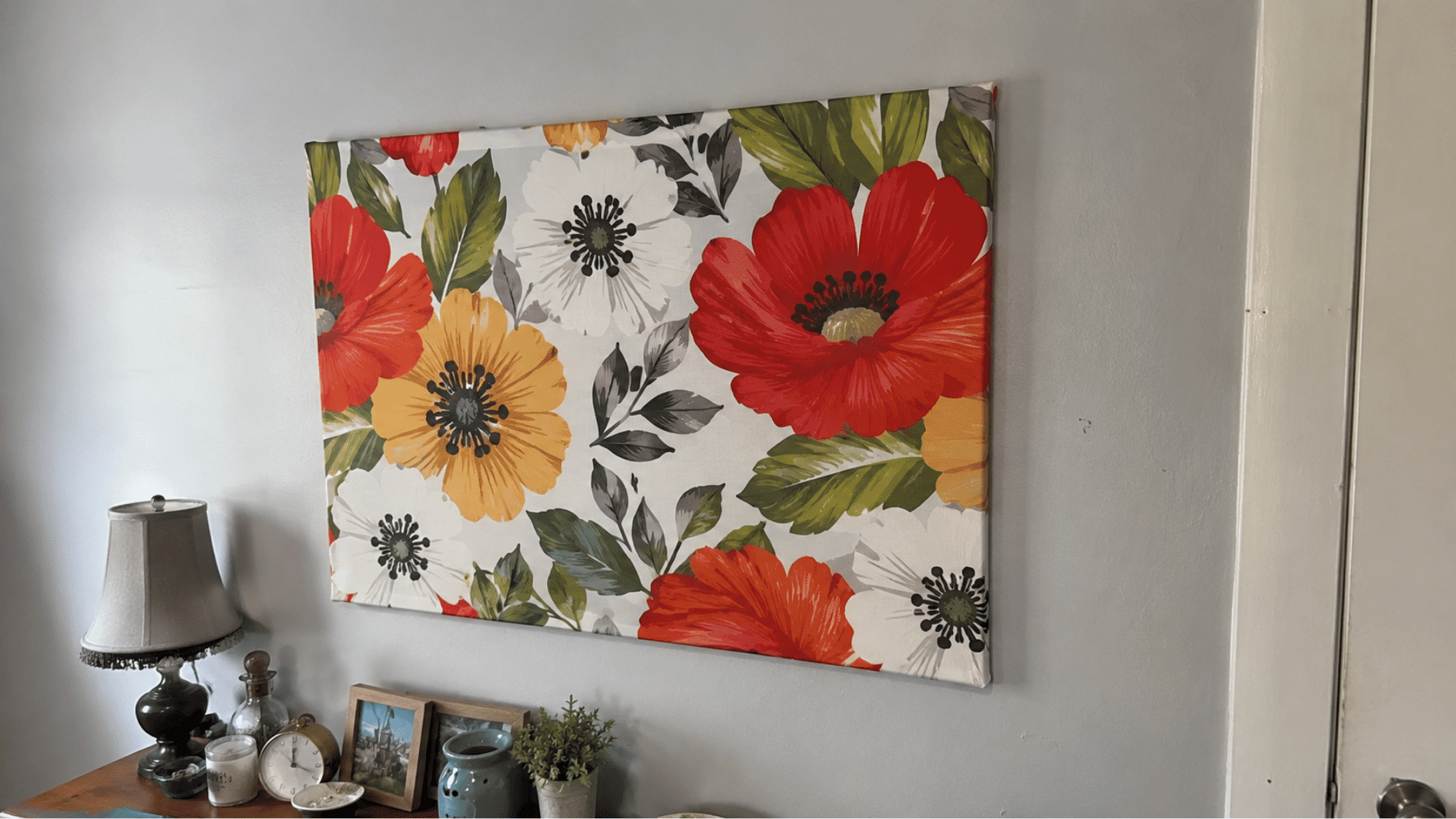 Bold floral fabric canvas art on a living room wall.