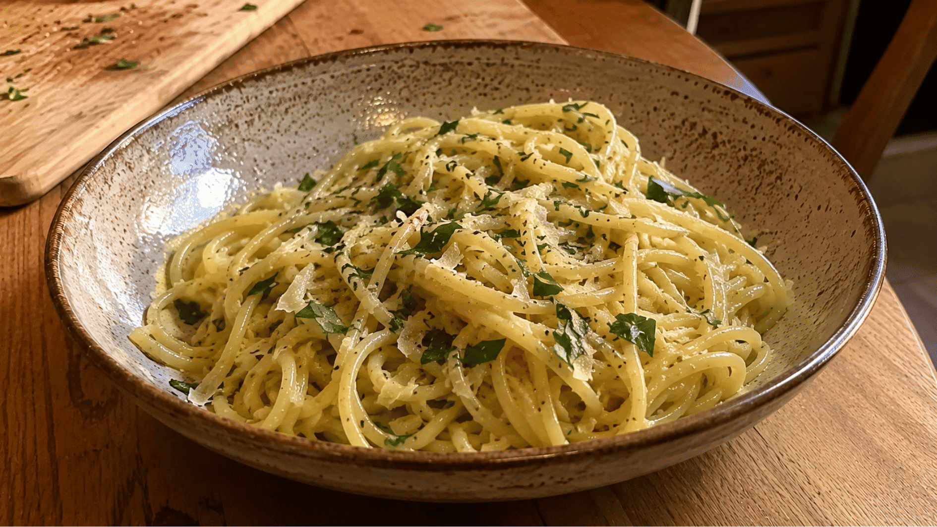 Spaghetti tossed in garlic butter with shaved parmesan and parsley in a rustic bowl