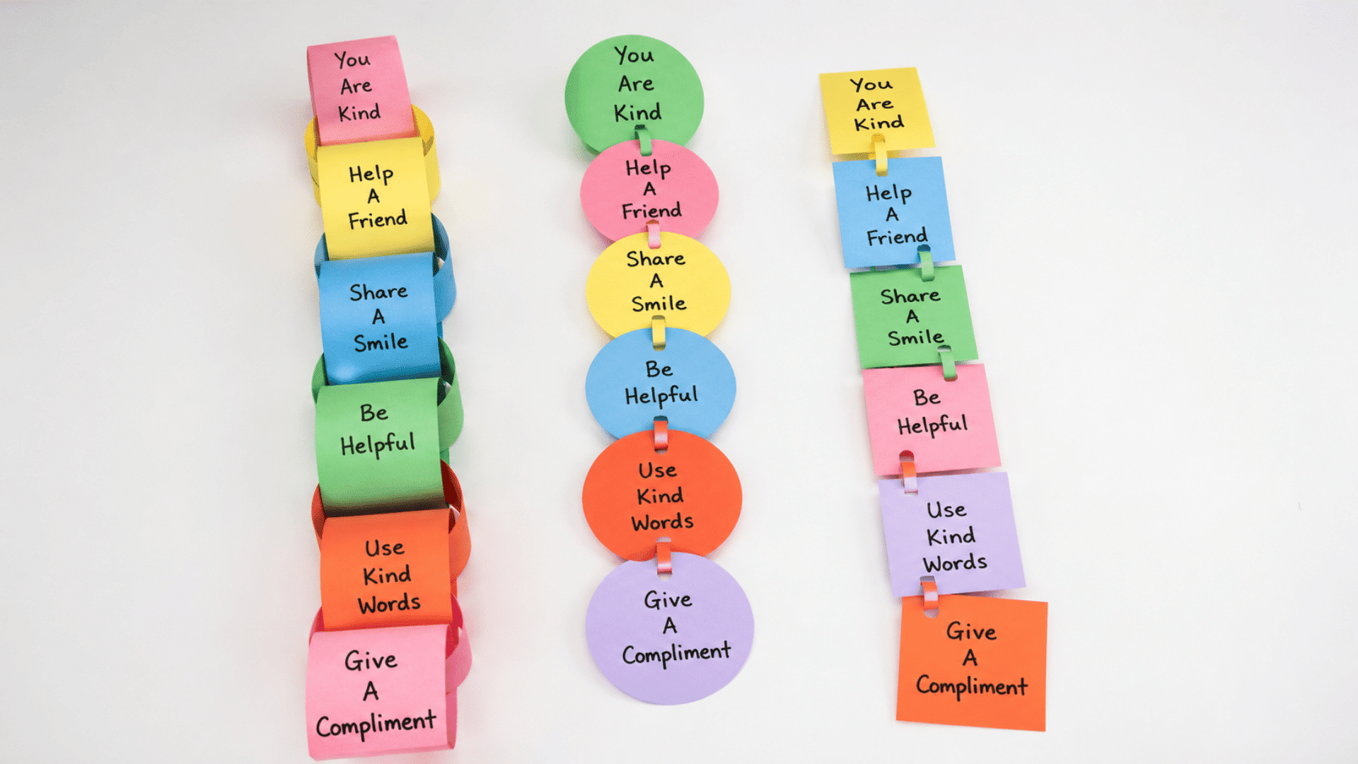a line of colorful handmade paper compliment chain loops linked together with nice messages written on every link