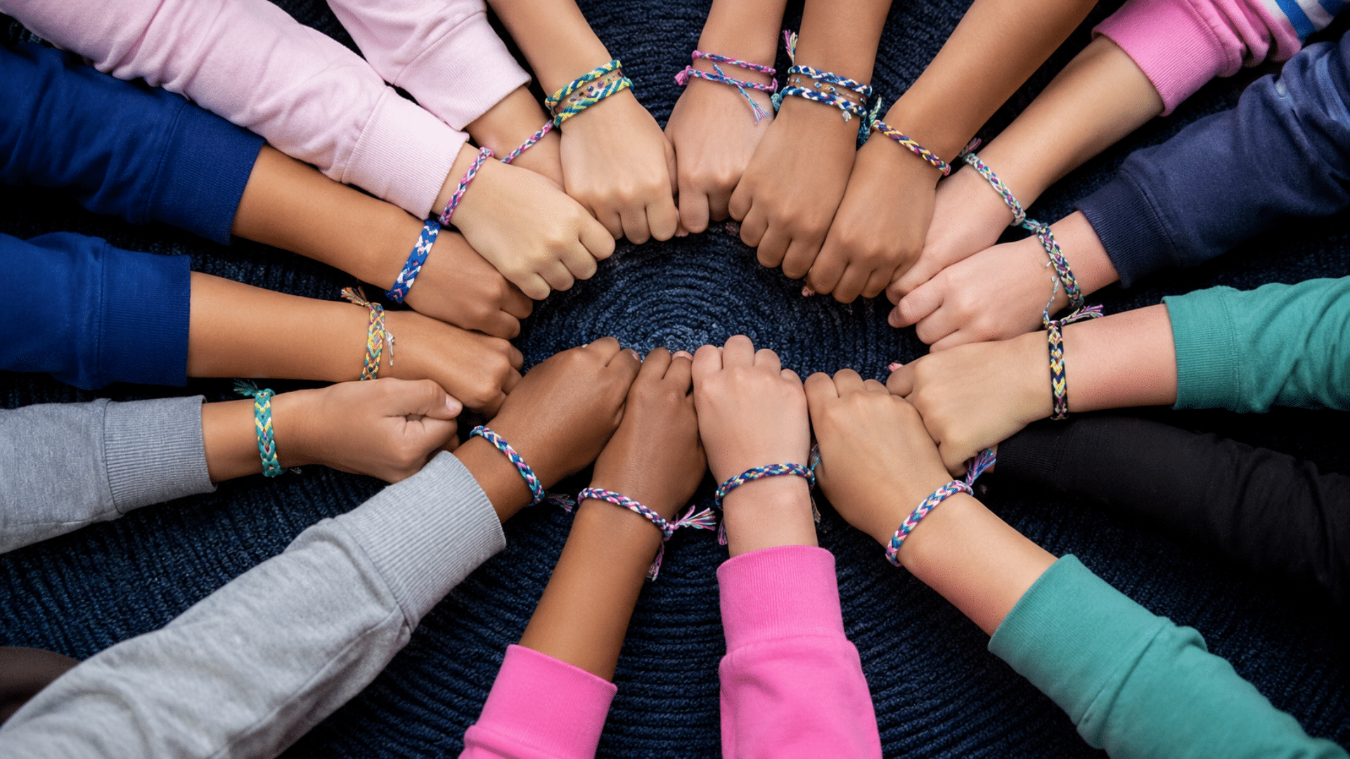 children showing colorful friendship bracelets braided with vibrant embroidery threads laid out together