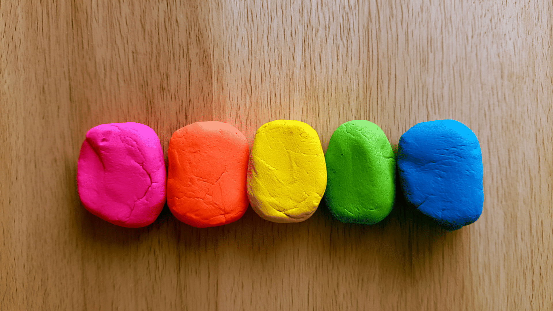 colored and painted flour and salt air dry clay pieces kept on a wooden table with minimalistic details and neutral lighting