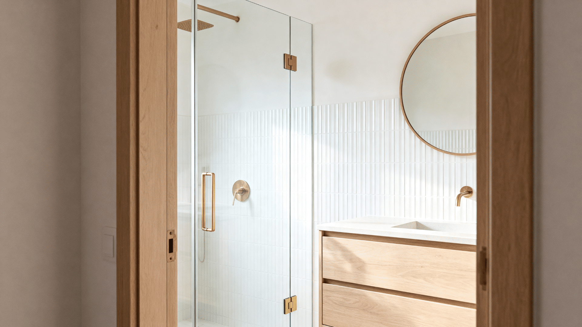 frameless small shower with slim brass hardware and white ribbed tile