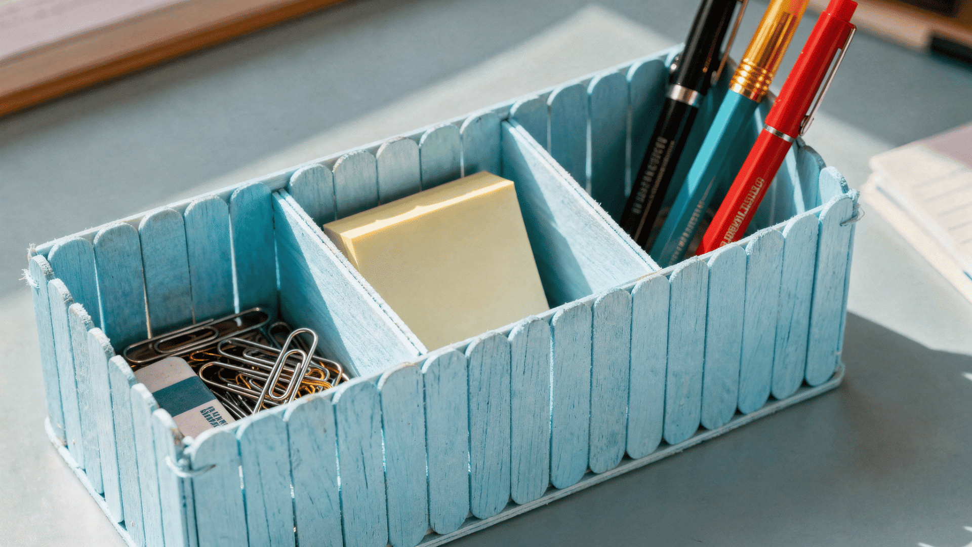 light blue mini desk organizer made from jumbo popsicle sticks with three sections