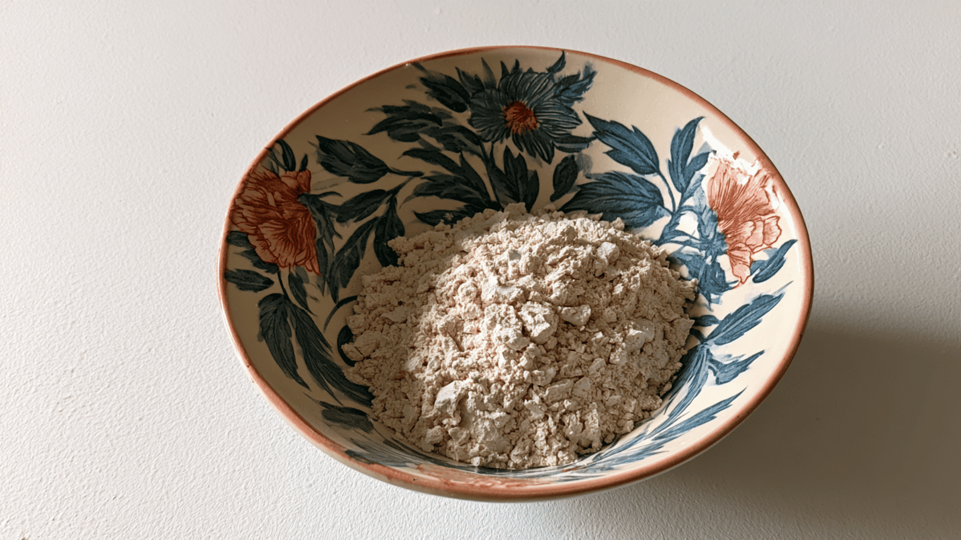 paper based air dry clay kept in a ceramic bowl with visible bowl design and shadow in a neutral background