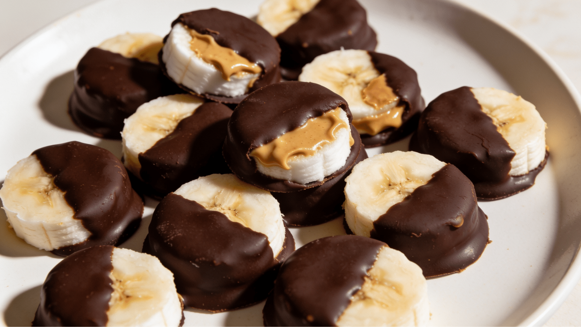 peanut butter banana bites dipped in chocolate and arranged on a plate for a kids party