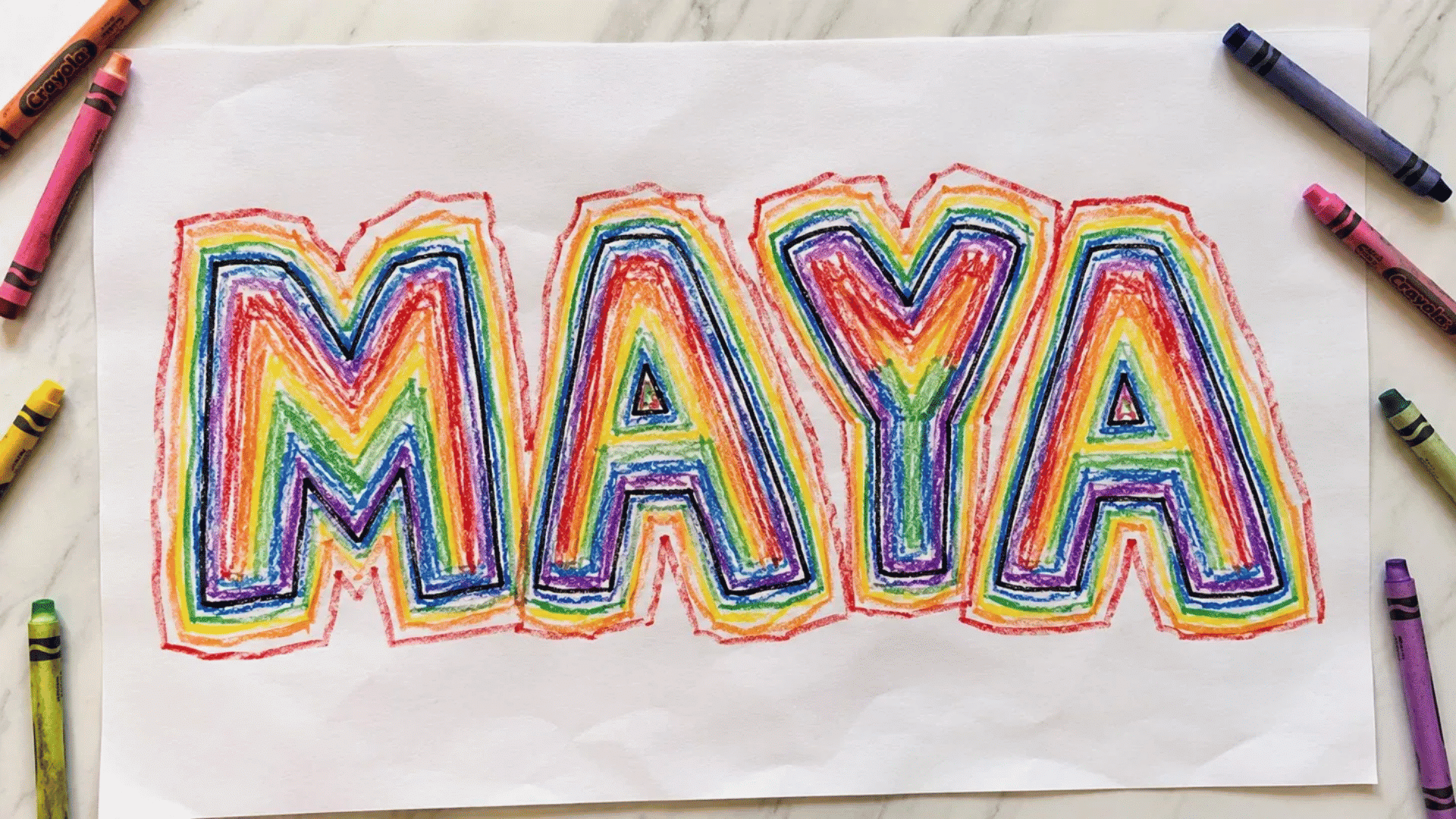 rainbow name art on white paper with colorful crayon outlines on marble surface