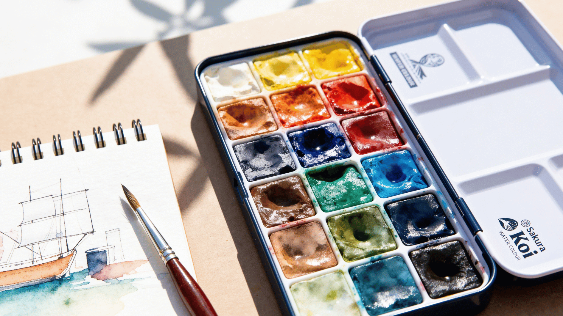 sakura koi travel watercolor set with sketchbook painting, compact palette, water brush and outdoor sketching setup