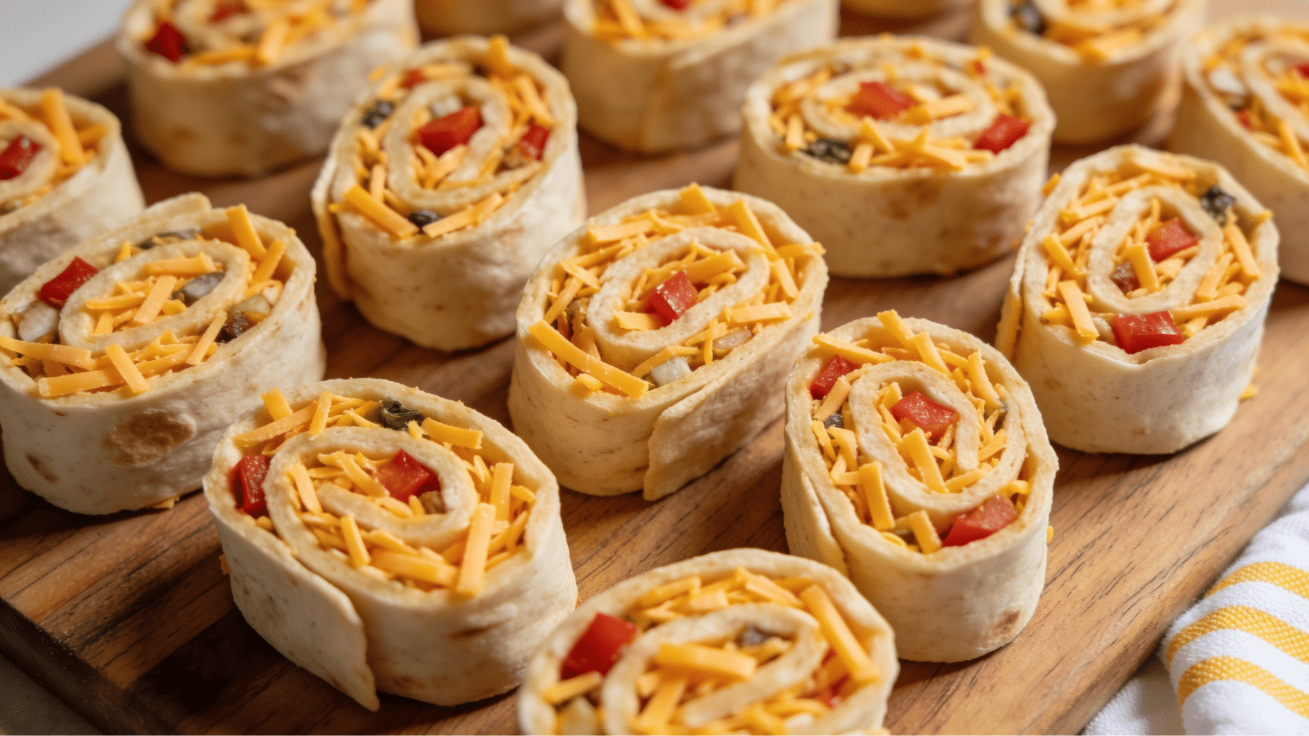turkey pinwheel rolls sliced into bite size spirals with cheese and lettuce on a platter
