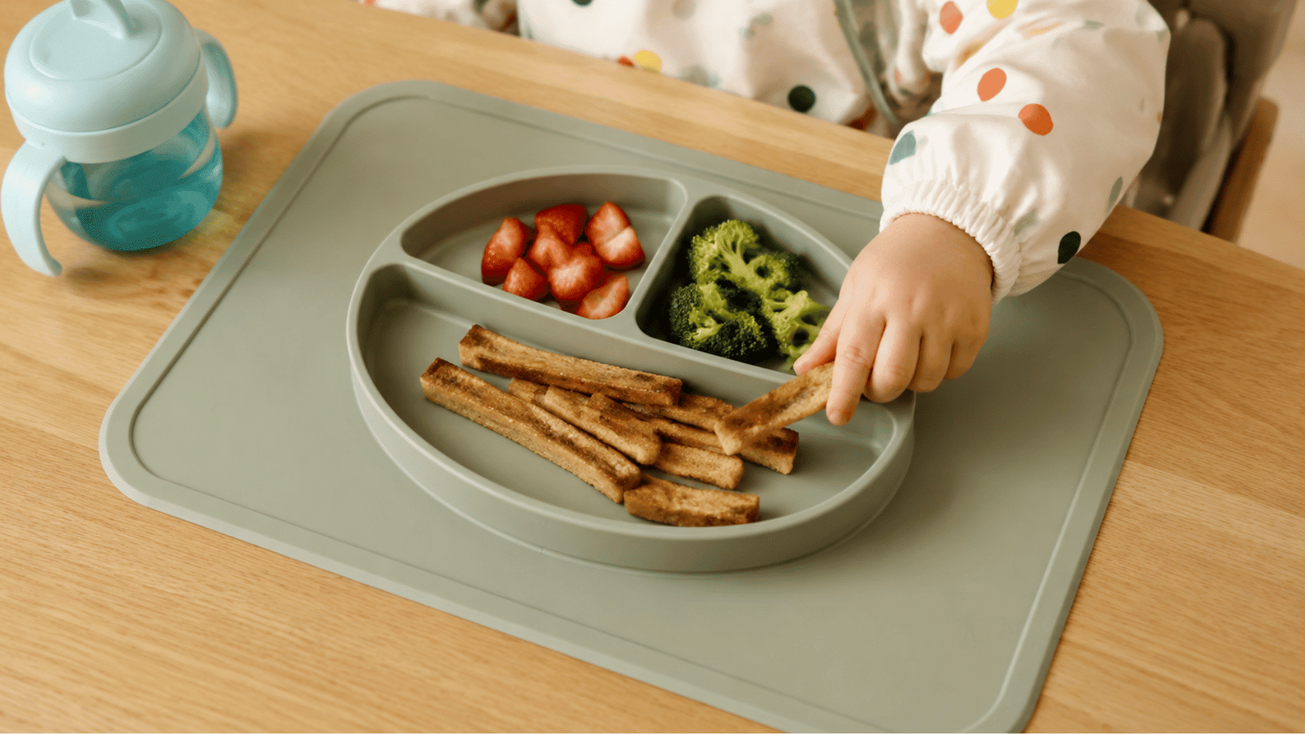 all in one placemat plate with divided food sections on a toddler table showing a wide silicone base design