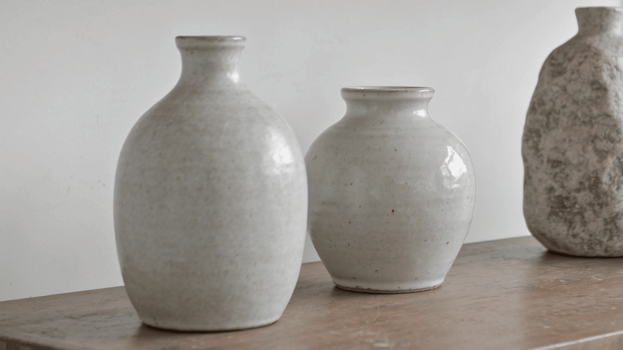ceramic and stone vases in neutral colors on transitional decor shelf