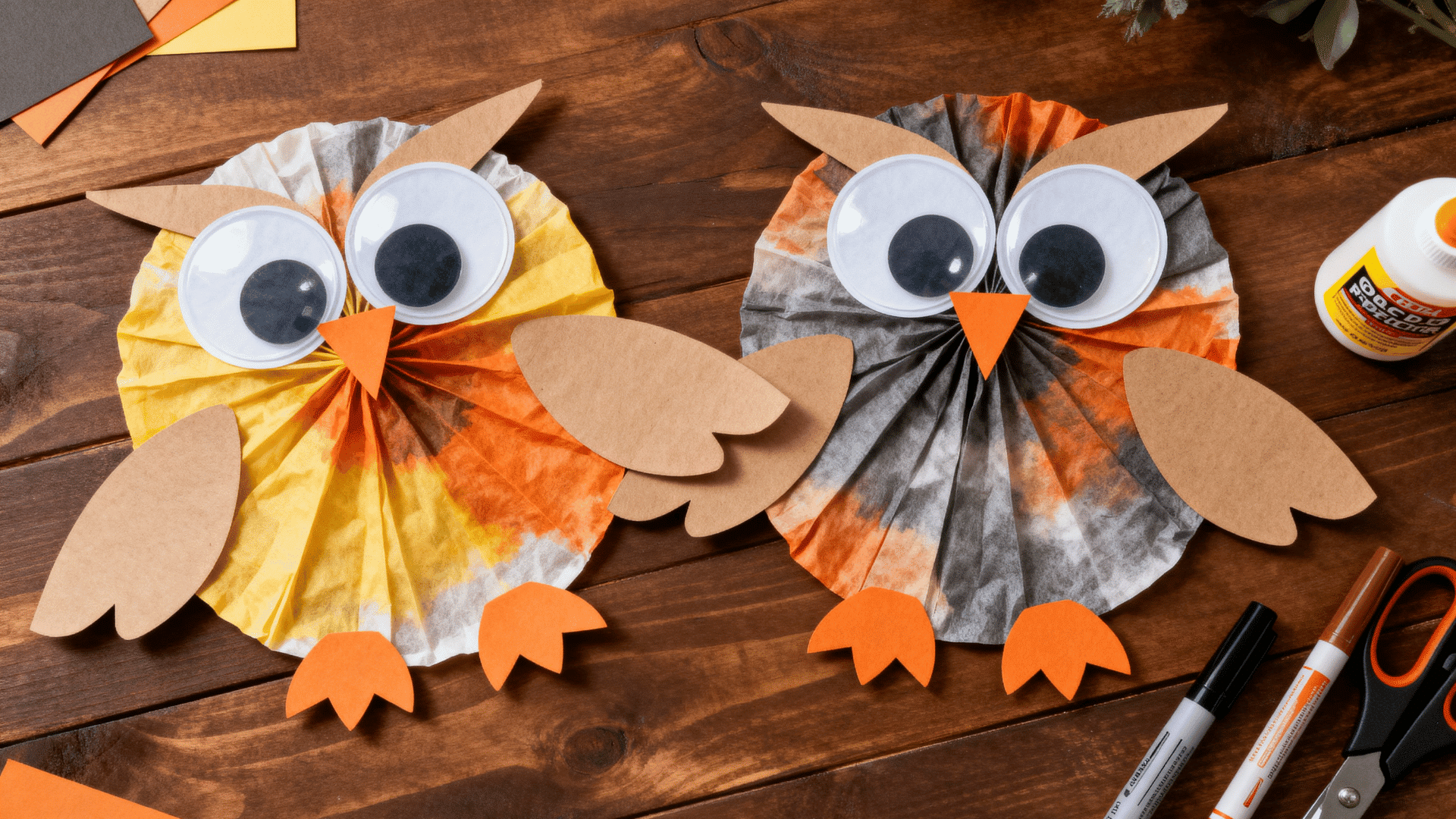 coffee filter owl craft with paper wings, beak, feet, large googly eyes, and warm woodland colors on a table with glue