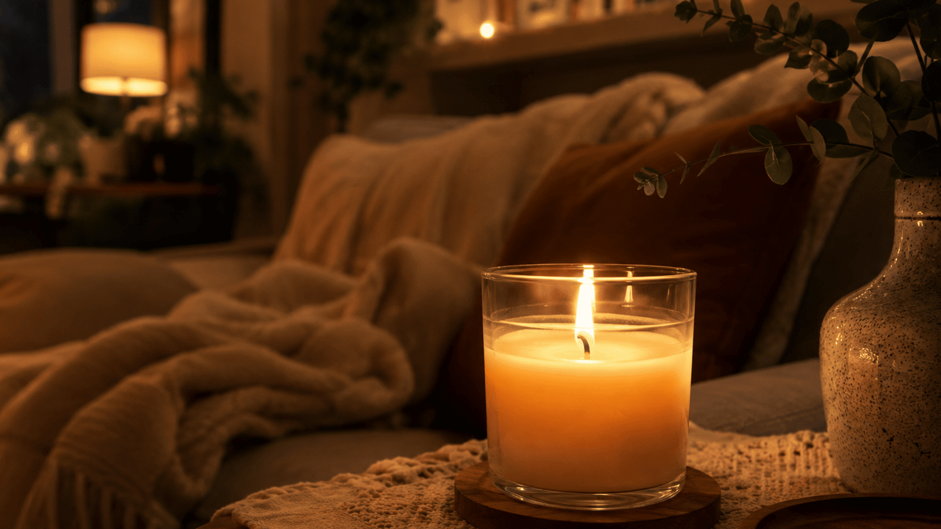 cozy lit candle in a glass jar creating a warm and inviting atmosphere in a comfortable living room with soft ambient lighting
