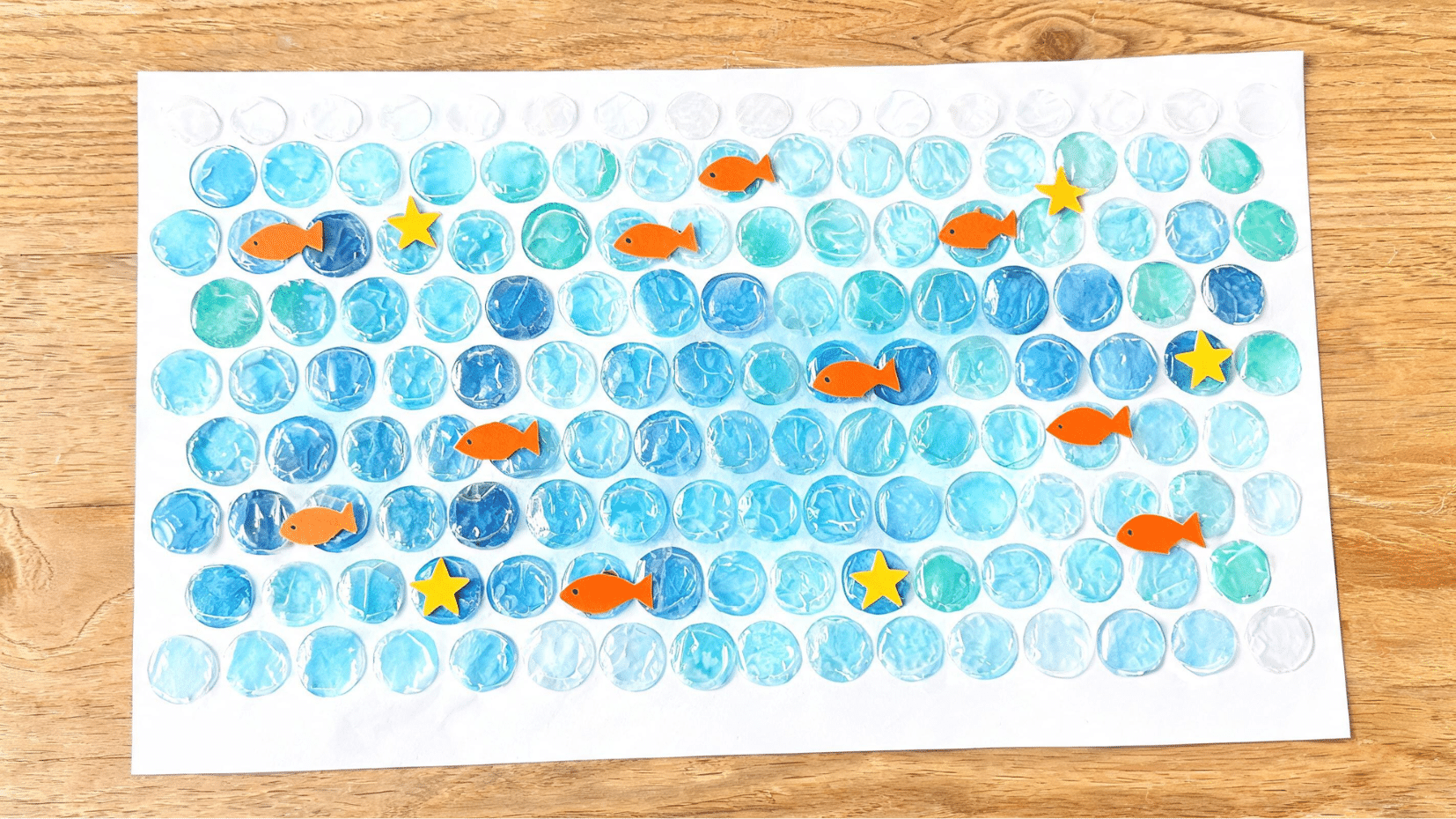craft paper with painted blue circles and orange fish (1)