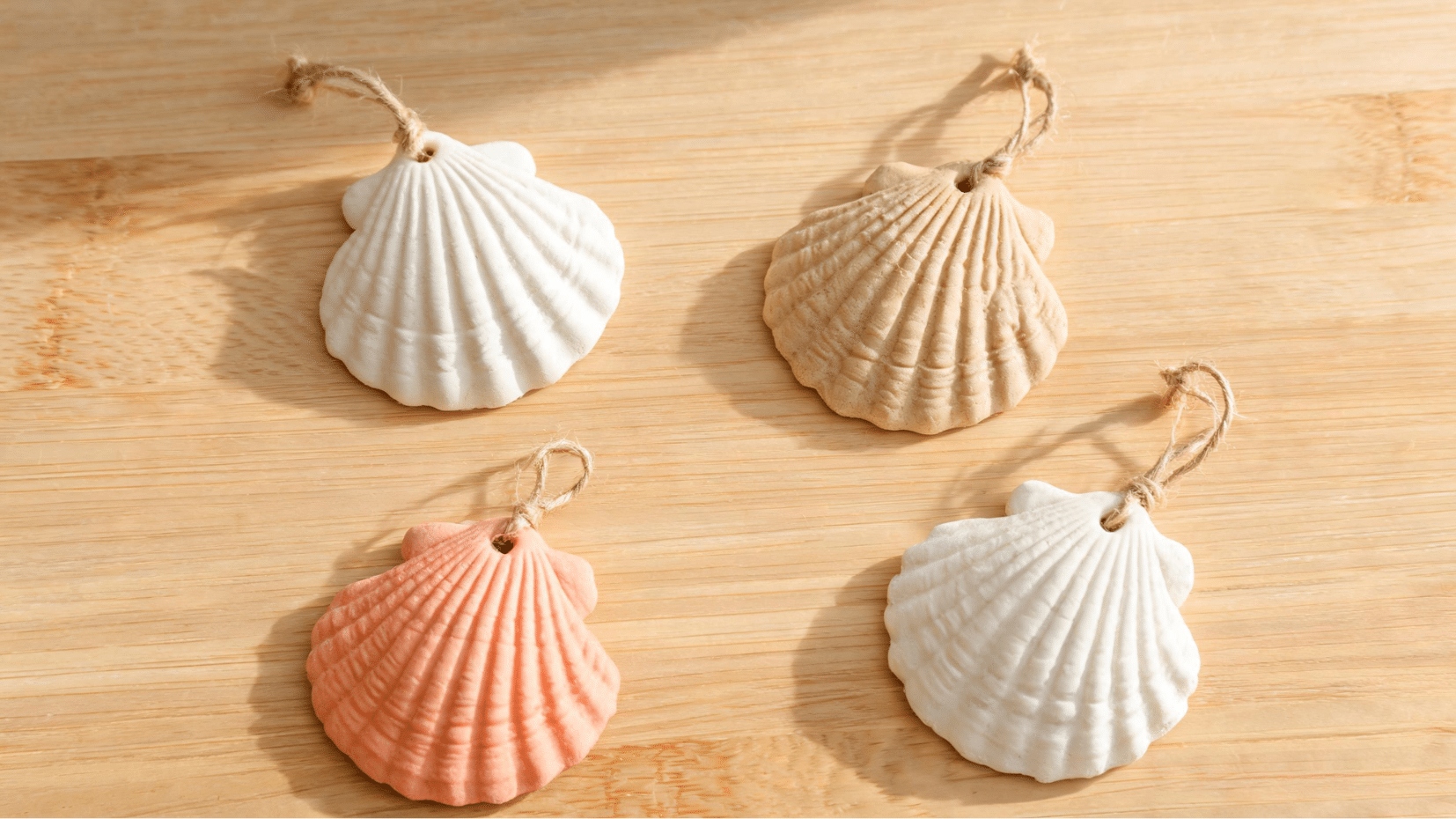 four decorative seashells on wooden surface in soft light (1)