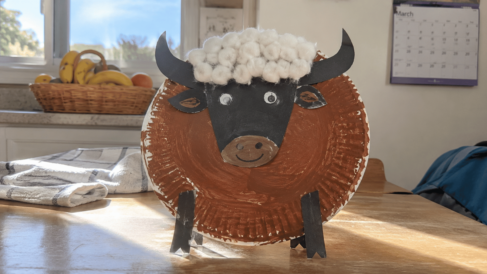 handmade brown paper plate buffalo craft with cotton mane on a kitchen table