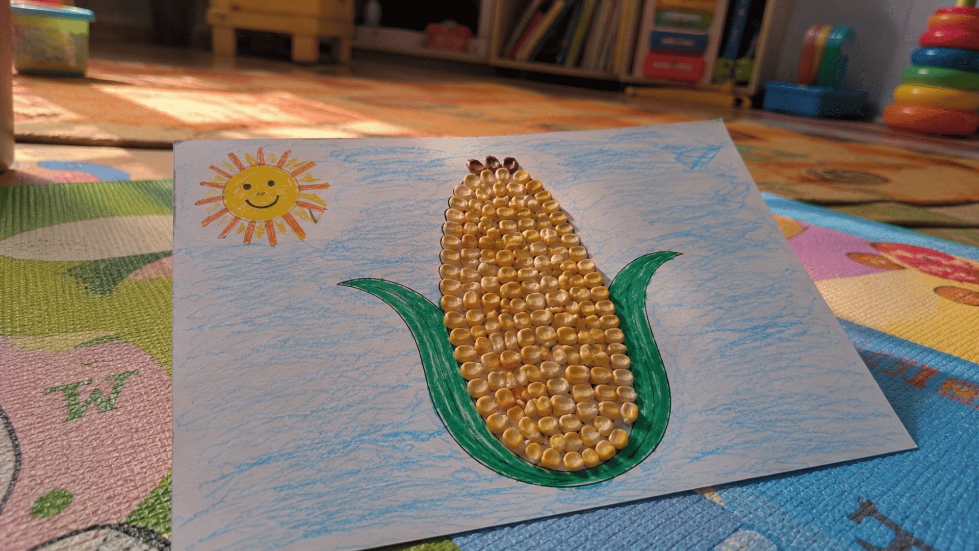 handmade corn kernel mosaic shaped like a corn cob on a kids' play mat
