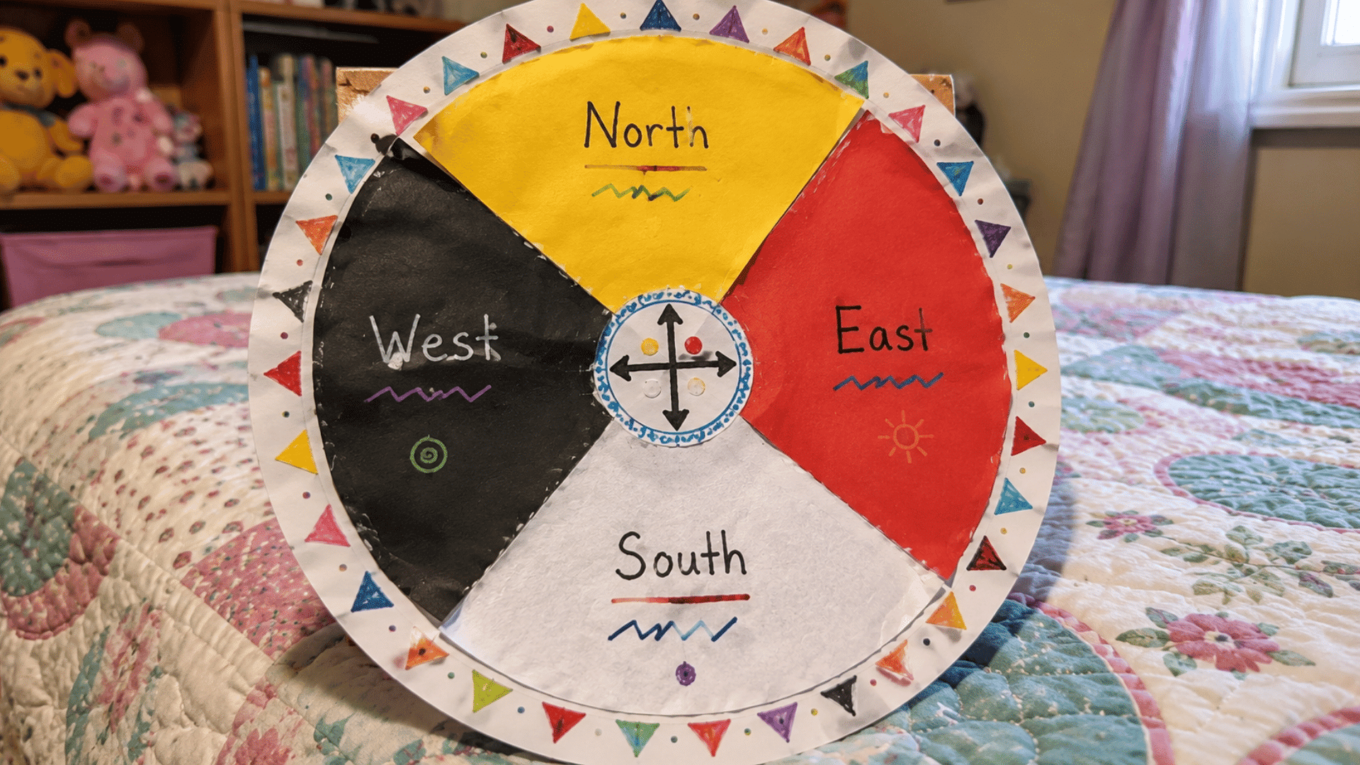 handmade four directions color wheel craft on a quilt in a child's bedroom