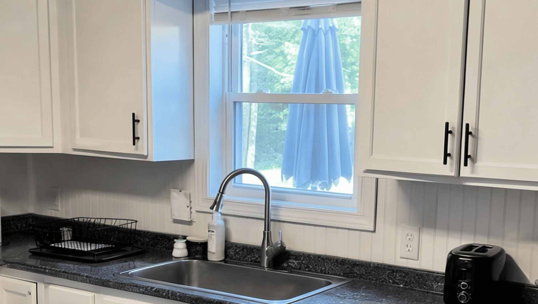 painted kitchen cabinets with updated hardware showing a simple affordable kitchen renovation idea