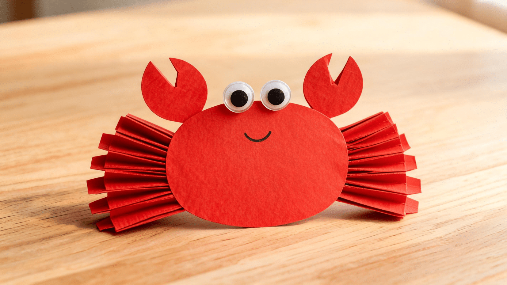 red paper crab craft on wooden table with googly eyes (1)