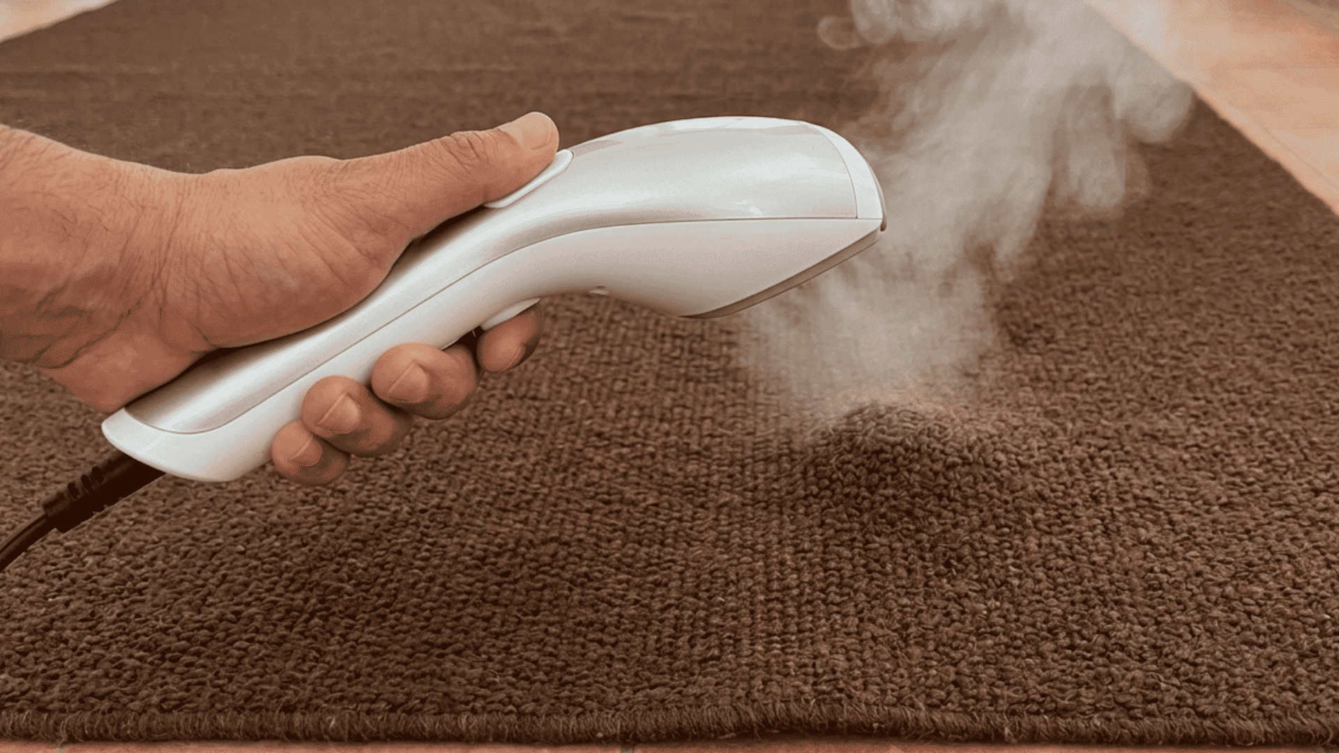 a garment steamer warming a curled rug edge on a living room floor to help the fibers relax and lie flat at home