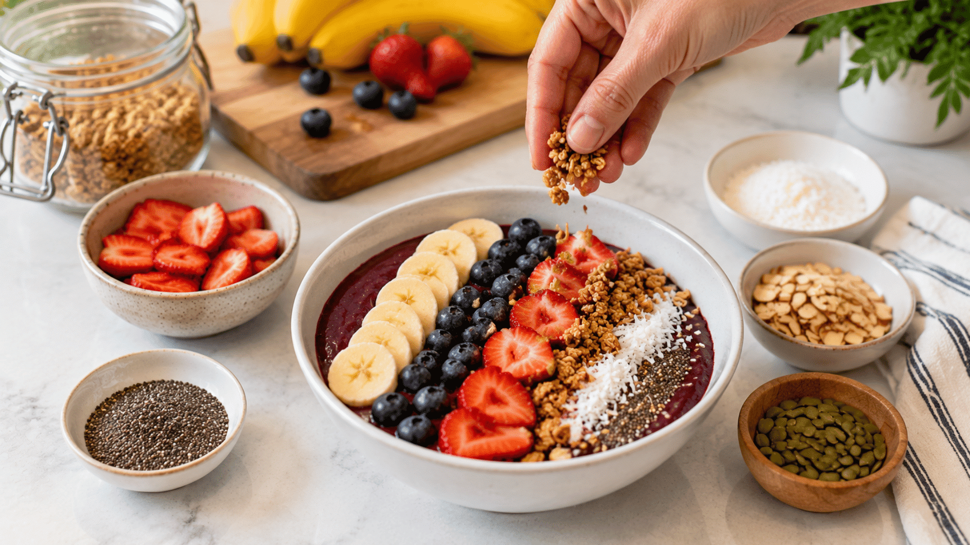 acai bowl topped with banana strawberries blueberries granola coconut seeds and fresh fruit toppings