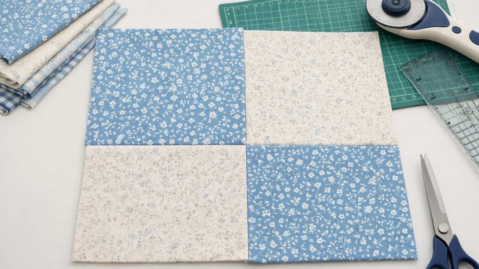 four patch quilt block with blue and cream squares showing simple beginner stitching details
