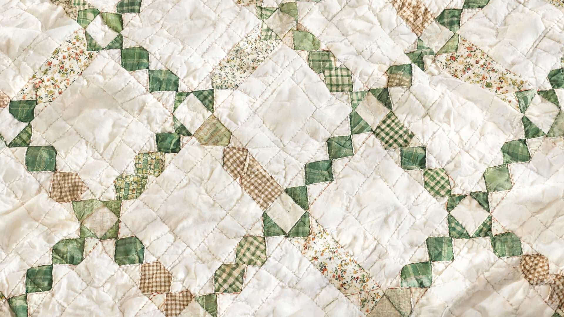 irish chain quilt with connected square patterns across a light fabric background