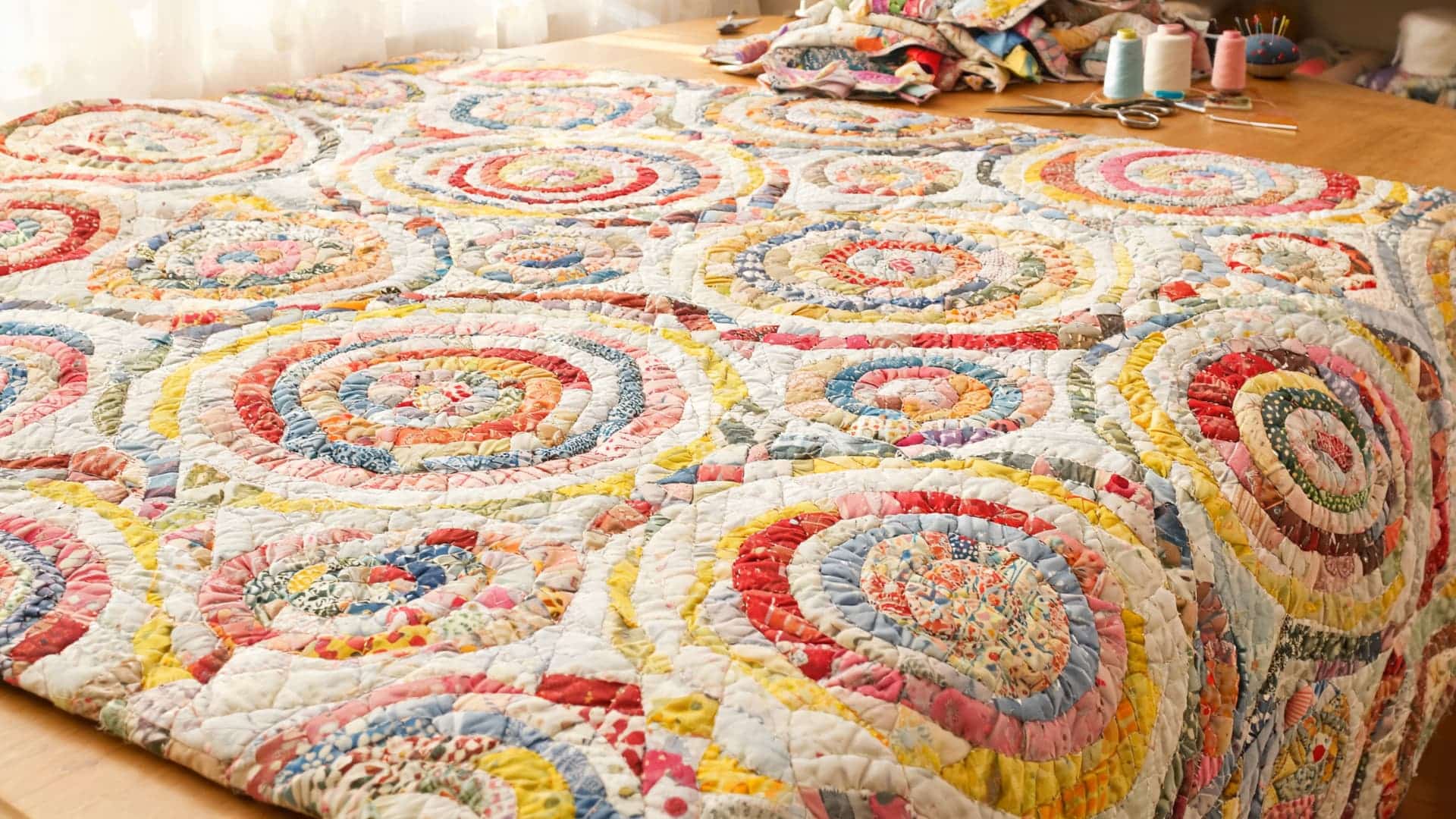 scrappy trip quilt with colorful fabric strips creating repeating circular patterns