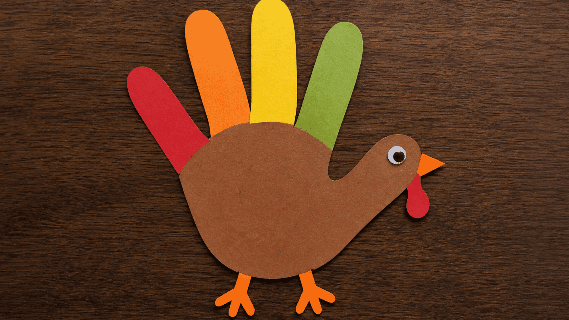 handprint turkey keepsake made from brown and colorful paper with a beak, wattle, and feet