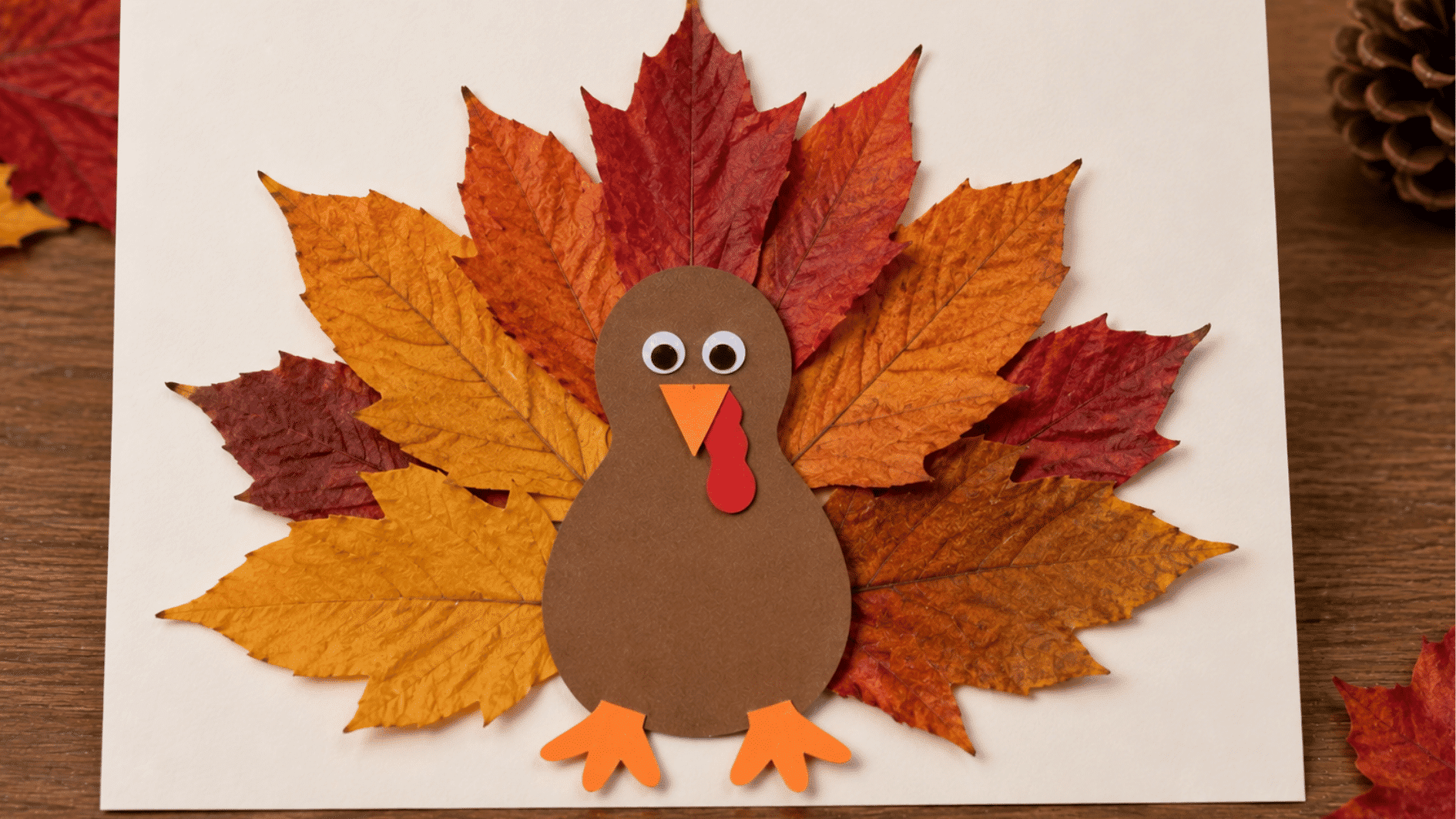 leaf turkey craft with real autumn leaves forming the tail and a brown paper turkey body
