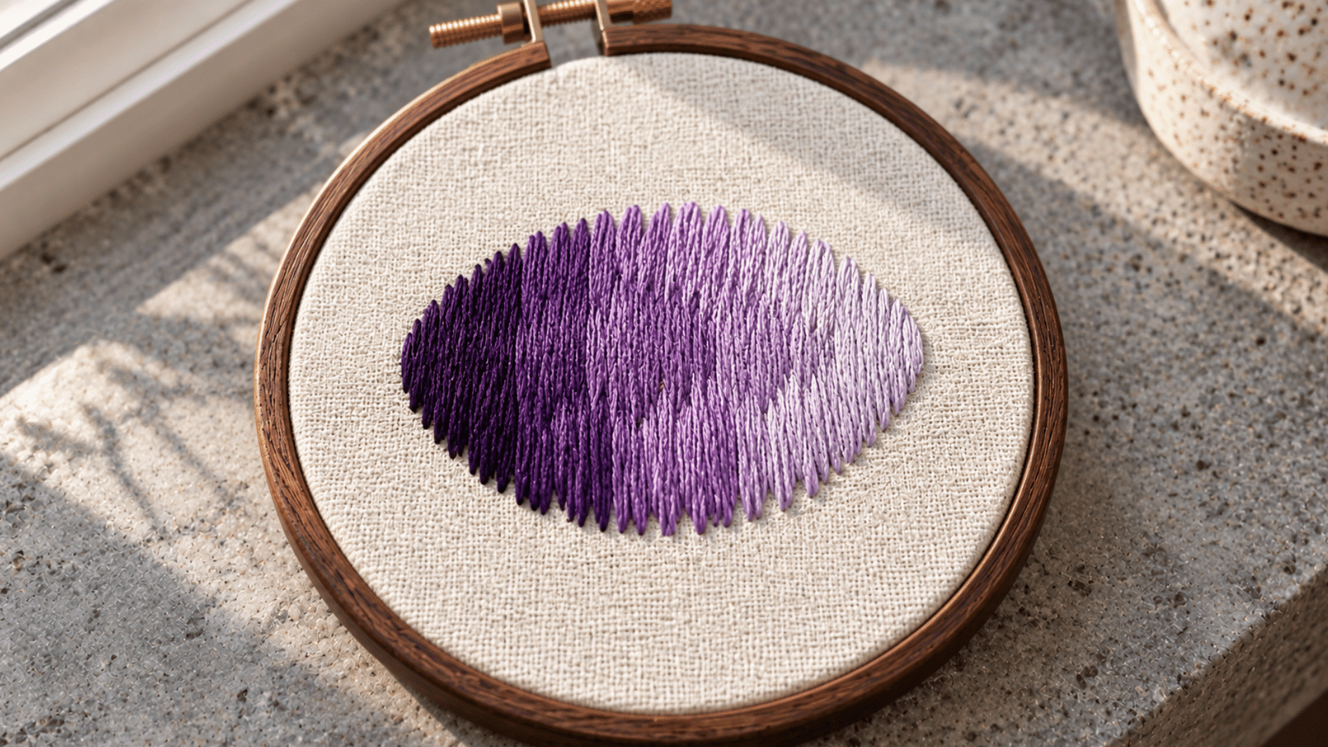 purple long and short stitch embroidery on ivory cotton showing staggered blended stitches from dark to light