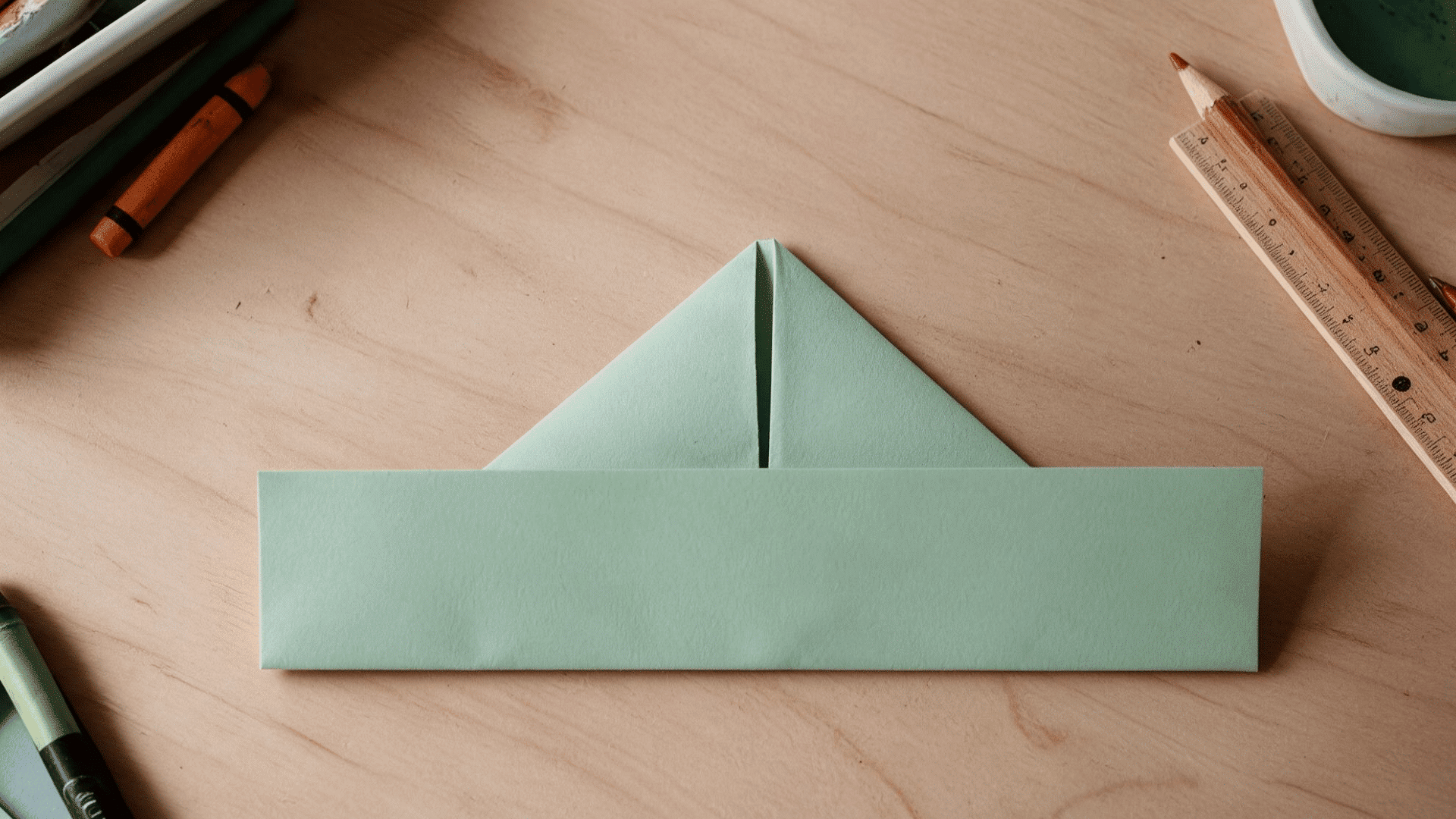 paper folded into a triangle sitting on a folded strip