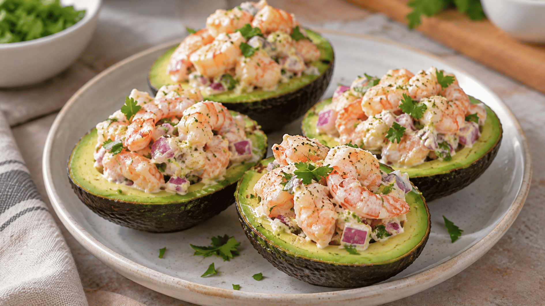 shrimp stuffed avocado halves filled with creamy shrimp red onion and herbs on a ceramic plate