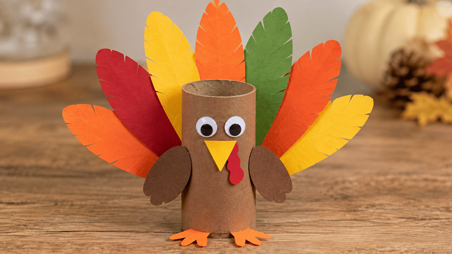 cardboard roll turkey craft with colorful paper feathers, wings, feet, beak, and wattle