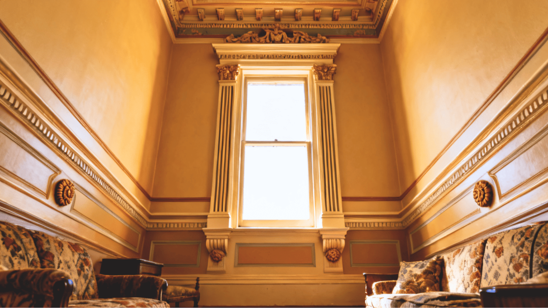 victorian interior with layered window trim featuring fluted casing rosette blocks and decorative crown molding around window frame